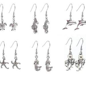 May include: Set of 10 silver tone dangle earrings featuring various sea life designs, including seahorses, starfish, mermaids, turtles, dolphins, and octopuses.