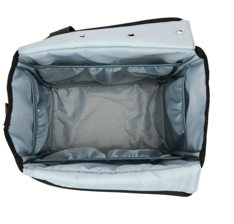 May include: An open black and light blue travel bag with multiple compartments and pockets. The bag is lined with a light blue fabric.