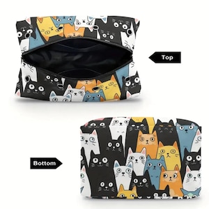 May include: A zippered pouch featuring a repeating pattern of cartoon cats in black, white, orange, and blue. The top view shows the open interior with metal grommets, while the bottom view displays the closed pouch with the same cat print.