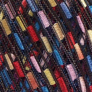 Puede incluir: Primer plano de un textil con un fondo oscuro y acentos bordados rectangulares coloridos. Los acentos son en tonos de rojo, amarillo, azul y rosa, creando un dise&ntilde;o texturizado y estampado. El bordado es detallado y est&aacute; tejido apretadamente.