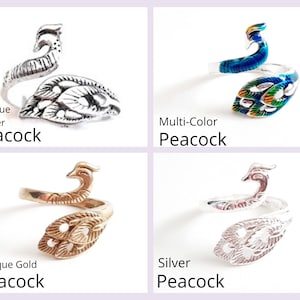May include: Four peacock-themed rings in antique silver, multi-color, antique gold, and silver. Each ring features a peacock design with the text "Peacock" below each ring.
