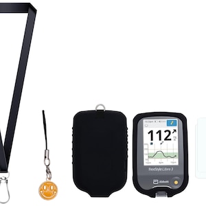May include: A black lanyard with a silver clasp, a yellow smiley face charm, a black protective case, a Freestyle Libre 3 glucose monitor displaying a reading of 112, and two clear adhesive patches.