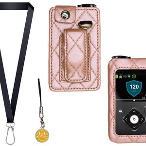 Puede incluir: Un cordón negro con un cierre plateado, un pequeño dije de carita sonriente amarilla y dos estuches de cuero acolchado rosa para un dispositivo médico. Un estuche tiene un clip para cinturón y el otro encierra el dispositivo.