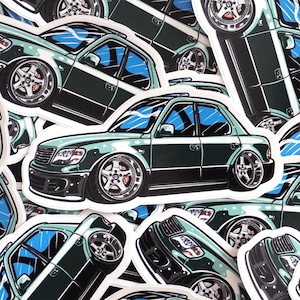 May include: A collection of stickers featuring a dark green sedan with lowered suspension and custom wheels. The car has blue tinted windows and a black lower trim. The stickers are die-cut and have a white border.