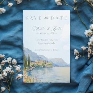 Peut inclure: Une carte de faire-part de mariage avec une peinture à l'aquarelle du lac de Côme, en Italie. La carte comprend le texte "SAVE the DATE", les noms "Sophie & Tyler" et la date du mariage, le 27 juin 2026. Les mots "formal invitation to follow" sont également inclus.