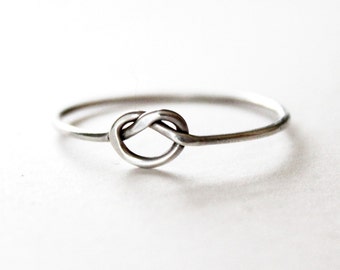 May include: A silver knot ring with a simple design.