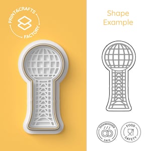 Puede incluir: Un cortador de galletas blanco y dorado con forma de globo y torre. El cortador tiene el texto "PRINT & CRAFTS FACTORY" y "Shape Example" en la imagen. La imagen también incluye los iconos "Dishwasher Safe" y "Food Safety".