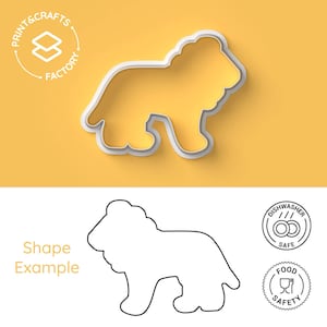 Op de afbeelding: Een witte koekjesvorm in de vorm van een leeuw met een gele binnenkant. De afbeelding bevat de tekst PRINT&CRAFTS FACTORY, Shape Example, DISHWASHER SAFE en FOOD SAFETY. Het ontwerp toont het silhouet van een staande leeuw met manen.