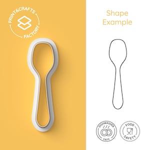 Può includere: Un tagliabiscotti a forma di cucchiaio bianco con interno giallo, accanto a un disegno a tratto nero e bianco di un cucchiaio. L'immagine include il testo "Shape Example" e icone che indicano la lavastoviglie e la sicurezza alimentare.