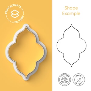 May include: A white plastic cookie cutter in a quatrefoil shape, with a matching shape example in black and white. The cutter is on a yellow background, with the text "Print & Crafts Factory" and icons indicating dishwasher and food safety.