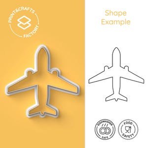 Puede incluir: Un cortador de galletas de avión blanco sobre un fondo amarillo. El cortador tiene forma de avión con alas y cola. La imagen también incluye un contorno en blanco y negro del cortador, junto con dos iconos de seguridad: uno para lavavajillas y otro para alimentos.