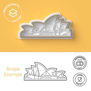 Könnte beinhalten: Ein weißer Plastik-Ausstecher in Form des Opernhauses von Sydney. Der Ausstecher befindet sich auf einem gelben Hintergrund. Der Text "Print & Crafts Factory" befindet sich in einem Kreis um einen Stapel Kisten in der oberen linken Ecke des Bildes.