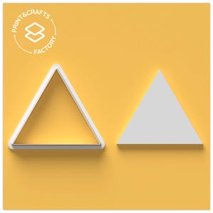 Puede incluir: Dos cortadores de galletas triangulares blancos sobre un fondo amarillo. Uno es un marco, el otro un tri&aacute;ngulo s&oacute;lido. El logotipo de Print & Crafts Factory est&aacute; en la esquina superior izquierda.