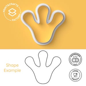 Peut inclure: Emporte-pièce en plastique blanc en forme de main à quatre doigts. L'emporte-pièce est sur un fond jaune. L'image montre également un dessin au trait noir et blanc de l'emporte-pièce et deux icônes indiquant que l'emporte-pièce est compatible lave-vaisselle et alimentaire.