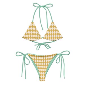 May include: A yellow and white checkered bikini with green straps. The top is a triangle style and the bottom is a tie-side style.