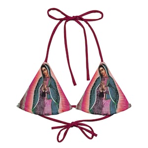 May include: A pink triangle bikini top with a print of the Virgin Mary. The top has adjustable straps and ties at the back.