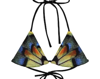 May include: A triangle bikini top featuring a vibrant butterfly wing pattern in shades of yellow, blue, orange, and green. The top has black ties at the neck and back for an adjustable fit. The design mimics the intricate details of a butterfly wing.