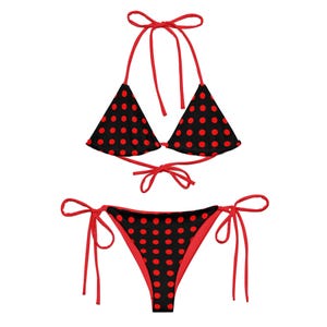 Puede incluir: Un bikini de lunares rojos y negros con tirantes ajustables. La parte superior es de estilo triangular y la inferior es de corte atrevido.