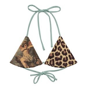 May include: A light blue triangle bikini top with a print of a cherub on one side and a leopard print on the other side.