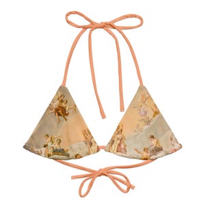 May include: A peach-colored bikini top with adjustable straps. The fabric features a vintage print of angels and cherubs in a cloudy sky.