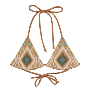 May include: A brown triangle bikini top with a geometric pattern in shades of blue, green, and white. The top has adjustable straps and ties at the back.