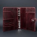 May include: A deep burgundy leather binder featuring a six-ring silver metal mechanism in the center. The interior includes multiple vertical card slots on the left side, a full-length pocket, and a snap-button closure tab on the right side.