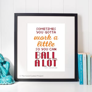 May include: A framed print with a white background and red and orange text that reads "SOMETIMES YOU GOTTA work a little SO YOU CAN BALL A LOT TOM HAVERFORD". The print is in a black frame and is sitting on a white surface. The text is in a pixelated font.