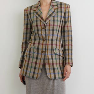 May include: A brown, green, blue, and red plaid blazer with a single-breasted closure and two front pockets.