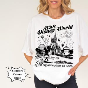 May include: White t-shirt featuring a black and white graphic of the Walt Disney World castle, Mickey Mouse, and the text "Walt Disney World" and "The happiest place on earth".