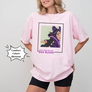 May include: Pink oversized t-shirt with a graphic print of Maleficent from Disney's Sleeping Beauty. The graphic features Maleficent with her raven and the text "Baby now we got bad blood".