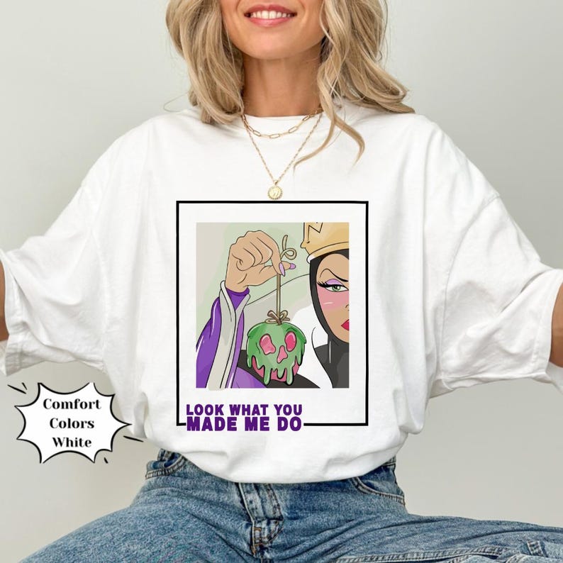 K&ouml;nnte beinhalten: Wei&szlig;es T-Shirt mit einem Grafikdruck der b&ouml;sen K&ouml;nigin aus Schneewittchen, die einen vergifteten Apfel h&auml;lt. Der Text "Look what you made me do" ist unter dem Grafikdruck aufgedruckt.