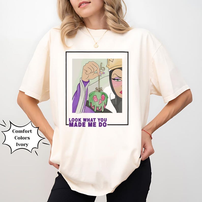 K&ouml;nnte beinhalten: Ein wei&szlig;es T-Shirt mit einem Grafikdruck der b&ouml;sen K&ouml;nigin aus Schneewittchen, die einen vergifteten Apfel h&auml;lt. Der Text "Look what you made me do" ist unter dem Grafikdruck aufgedruckt.