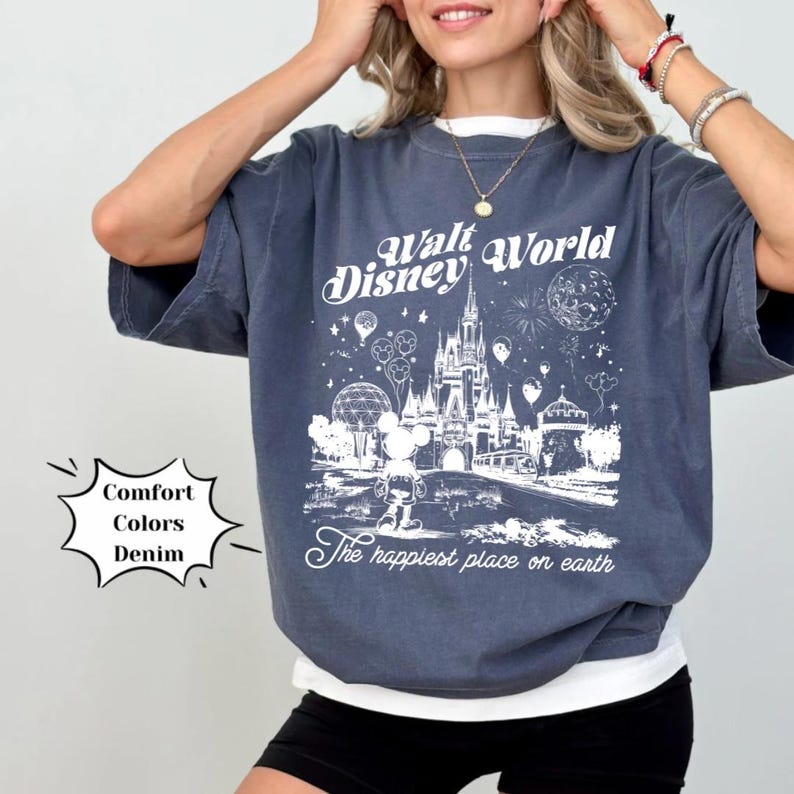 May include: A dark blue t-shirt featuring a white graphic of the Walt Disney World castle and Mickey Mouse. The text "Walt Disney World" and "The happiest place on earth" are printed on the shirt.