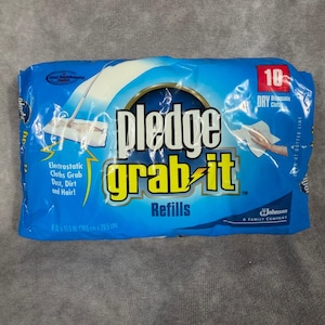May include: A blue package of Pledge Grab-It refills. The package features the Pledge logo in yellow and the words "Electrostatic Cloths Grab Dust, Dirt and Hair!" The package contains 10 dry disposable cloths and measures 8 x 11.5 inches.