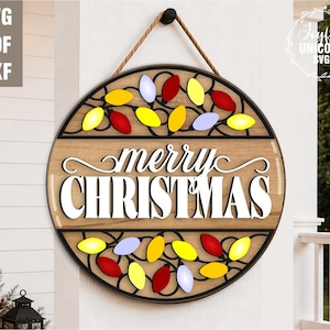 May include: A round wooden Christmas sign with the words "merry CHRISTMAS" in white script. The sign is decorated with colorful string lights in red, yellow, and blue. It hangs from a rope and is suitable for outdoor use.