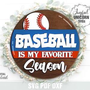 以下が含まれることがあります： 野球のグラフィックと「BASEBALL IS MY FAVORITE SEASON」の文字が入った丸い木製の看板。看板には野球ボール、青と赤のアクセント、装飾的なリースが描かれています。「Joyful Unicorn SVGs」と「Digital Download」の文字も表示されています。