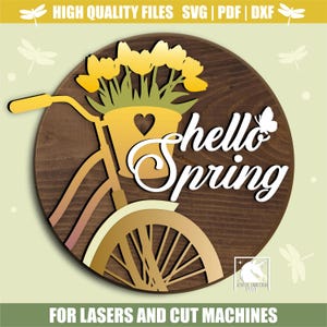 Puede incluir: Un letrero de madera redondo con una bicicleta que lleva flores amarillas en una cesta, con las palabras "hello Spring" en escritura blanca. El letrero tiene un fondo marrón y una bicicleta amarilla. El texto en la parte superior dice "HIGH QUALITY FILES SVG | PDF | DXF".