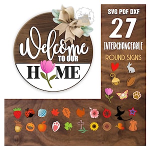 Könnte beinhalten: Runder Holzschild mit dem Schriftzug "Welcome to Our Home" in weißer Schrift. Eine rosa Tulpe und eine Schleife aus Jute schmücken das Schild. Das Bild zeigt auch 27 austauschbare runde Schilder, darunter ein Herz, ein Kaninchen und ein Kürbis.