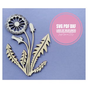 Może przedstawiać: Wycięcie z drewna z dmuchawcem z szczegółową główką nasienną, łodygą, liśćmi i pąkami. Projekt jest jasnobrązowy na fioletowym tle. Obraz zawiera tekst w różowym okręgu z napisem "SVG PDF DXF Laser Cut Wildflowers".