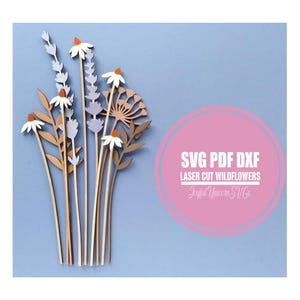 Può includere: Un bouquet di fiori selvatici tagliati al laser nei toni del marrone, bianco e lavanda, con centri arancioni. Il design include margherite, lavanda e altri elementi floreali. L'immagine contiene anche il testo "SVG PDF DXF Laser Cut Wildflowers Joyful Unicorn SVGs."