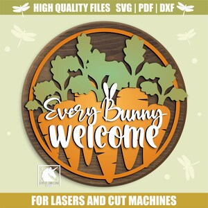 Op de afbeelding: Een ronde houten plaat met een wortelontwerp en de witte tekst "Every Bunny Welcome". Het bord heeft een bruine rand en groene bladeren. De tekst "FOR LASERS AND CUT MACHINES" staat onderaan.