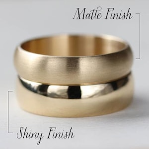 May include: Two gold-colored bands stacked vertically. The top band features a matte finish, while the bottom band has a shiny, polished finish. Text labels indicate Matte Finish for the top ring and Shiny Finish for the bottom ring.