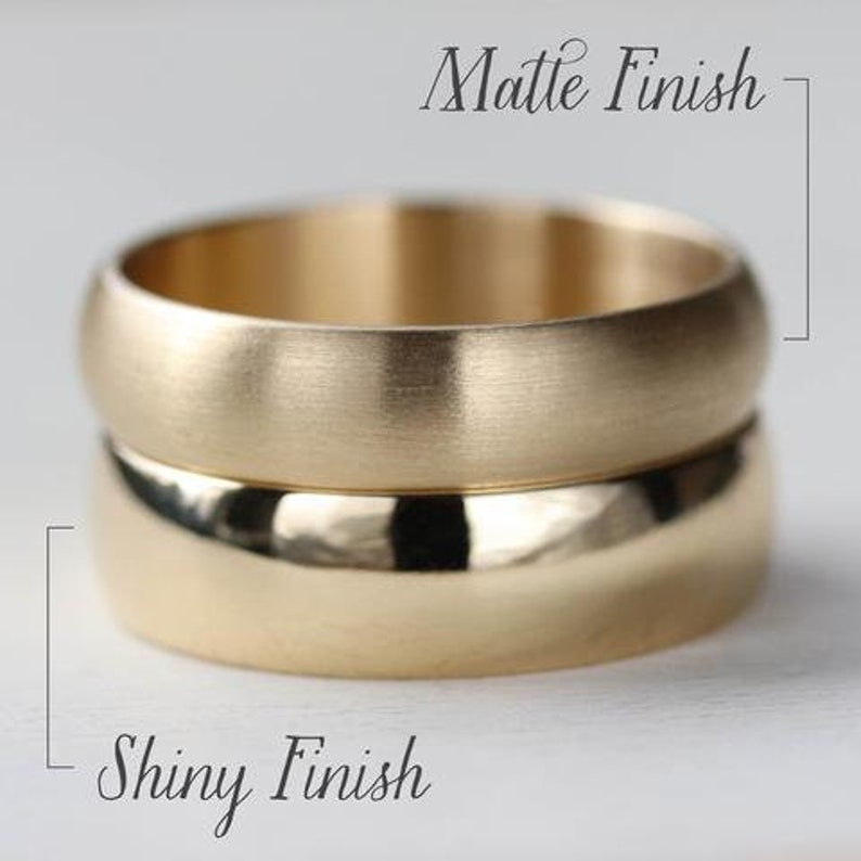 May include: Two gold-colored bands stacked vertically. The top band features a matte finish, while the bottom band has a shiny, polished finish. Text labels indicate Matte Finish for the top ring and Shiny Finish for the bottom ring.