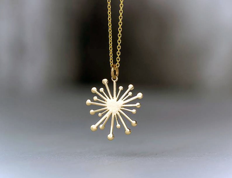 a small solid gold starburst dandelion necklace, snowflake pendant with a dainty chain. yellow, white rose gold sun charm