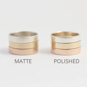 May include: Two stacks of three metal rings each. The left stack has a matte finish, and the right stack has a polished finish. Each stack contains a silver-colored ring, a gold-colored ring, and a rose gold-colored ring. The text MATTE and POLISHED appears below the respective stacks.