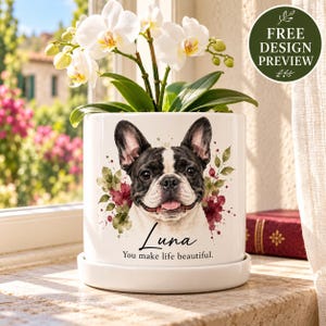 Könnte beinhalten: Ein weißer, zylindrischer Keramikübertopf mit Untersetzer, verziert mit einer Aquarellillustration einer schwarz-weißen Französischen Bulldogge. Der Text lautet Luna und You make life beautiful. Eine weiße Orchidee wächst im Topf.