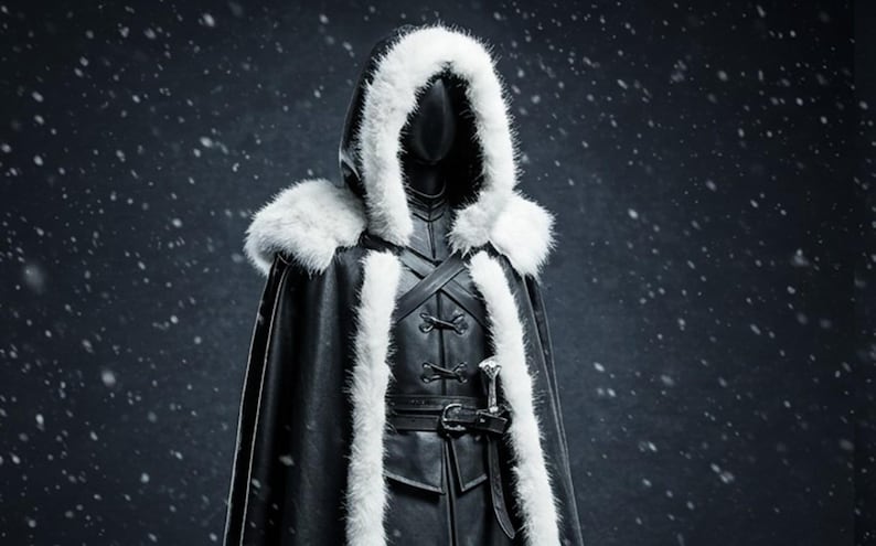 May include: A black leather hooded cloak with a white fur trim. The cloak has a belt and a silver buckle. The hood is pulled up and the face is not visible.