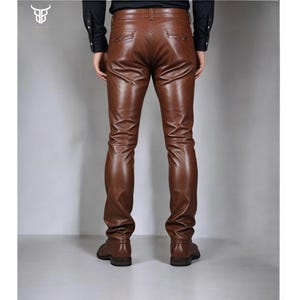 May include: Brown leather pants with a slim fit. The pants have a zipper fly and belt loops.