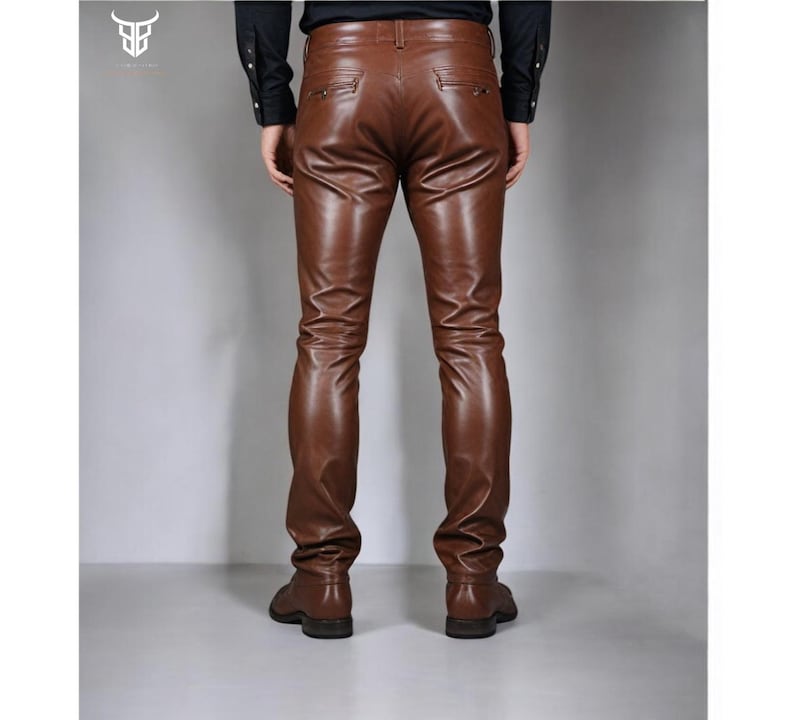 May include: Brown leather pants with a slim fit. The pants have a zipper fly and belt loops.