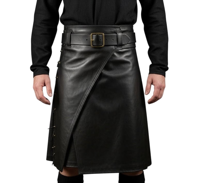 K&ouml;nnte beinhalten: Schwarzer Lederkilt mit Wickeldesign und G&uuml;rtel mit quadratischer Schnalle. Der Kilt hat dekorative N&auml;hte an der Seite. Getragen mit einem schwarzen Langarmshirt.